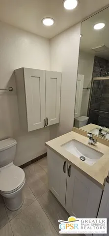 a bathroom with a sink a toilet and mirror