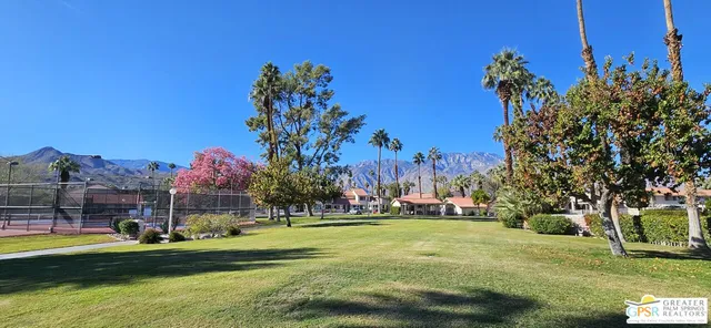 a view of a play house with a big yard and potted plants