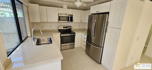 a kitchen with stainless steel appliances granite countertop a refrigerator a stove top oven a sink and dishwasher