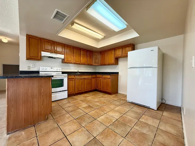 a kitchen with stainless steel appliances granite countertop a stove cabinets and refrigerator