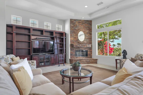 a living room with furniture a flat screen tv and a large window