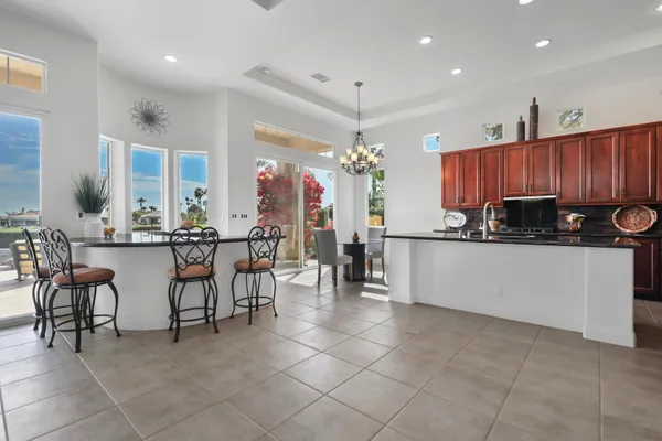 a kitchen with stainless steel appliances a stove a sink a oven a dining table and chairs