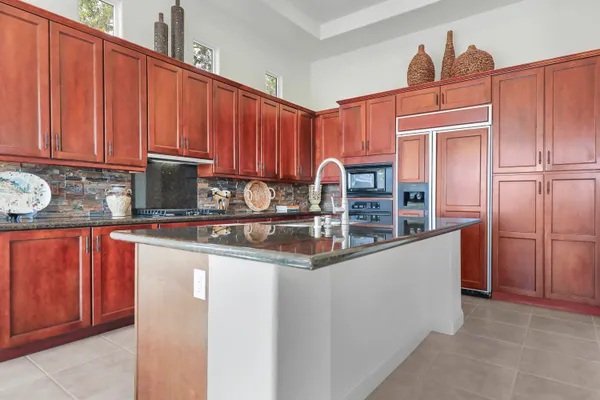 a kitchen with stainless steel appliances granite countertop a refrigerator and a sink
