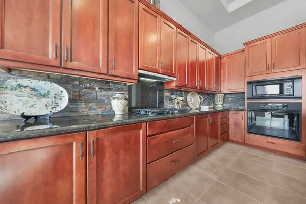 a kitchen with granite countertop a sink dishwasher stove and cabinets with wooden floor