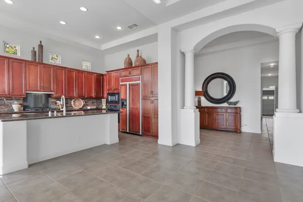 a kitchen with stainless steel appliances granite countertop a refrigerator a stove and a sink