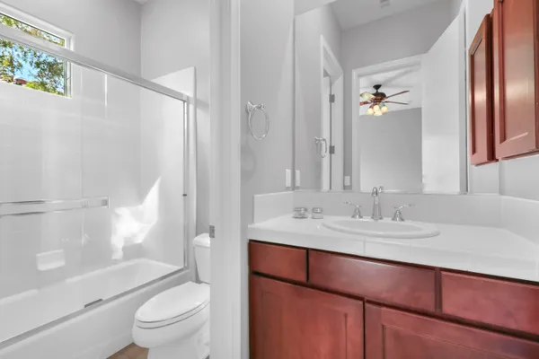 a bathroom with a granite countertop sink toilet a mirror a vanity and shower
