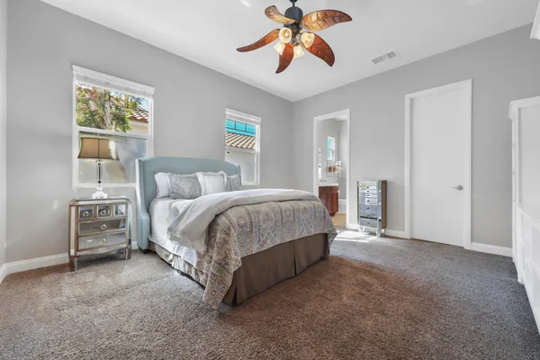 a spacious bedroom with a bed and a chandelier