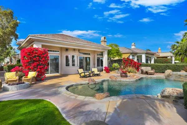 a view of a house with swimming pool and sitting area