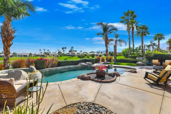 a view of a patio with swimming pool and furniture