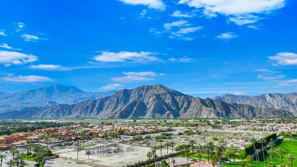 a view of a fountain in front of a house with a big yard