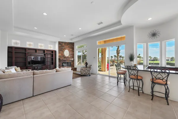 a living room with furniture a flat screen tv and a large window