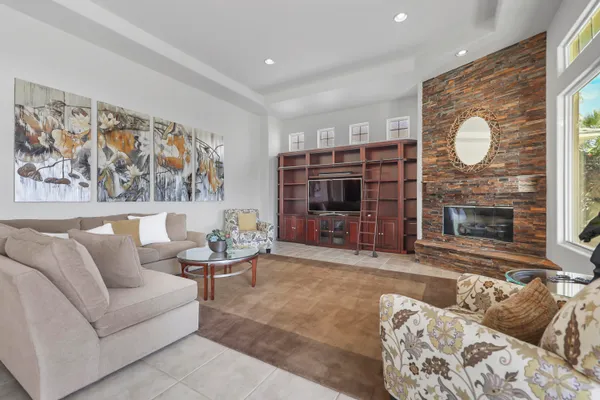 a living room with furniture a fireplace and a large window