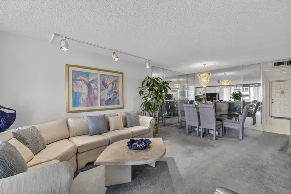 a living room with furniture and a dining table with kitchen view