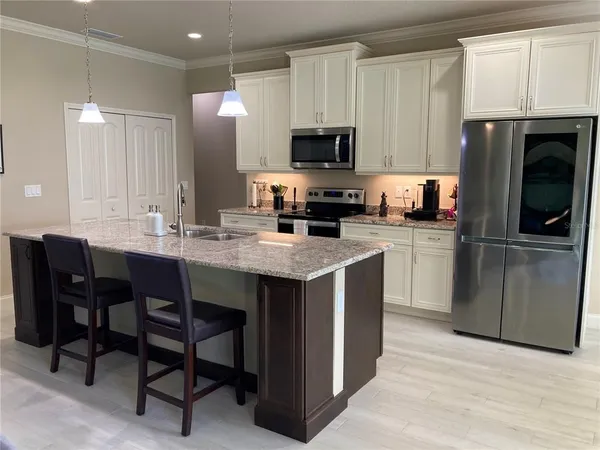 a kitchen with stainless steel appliances granite countertop a sink dishwasher and microwave with wooden floor