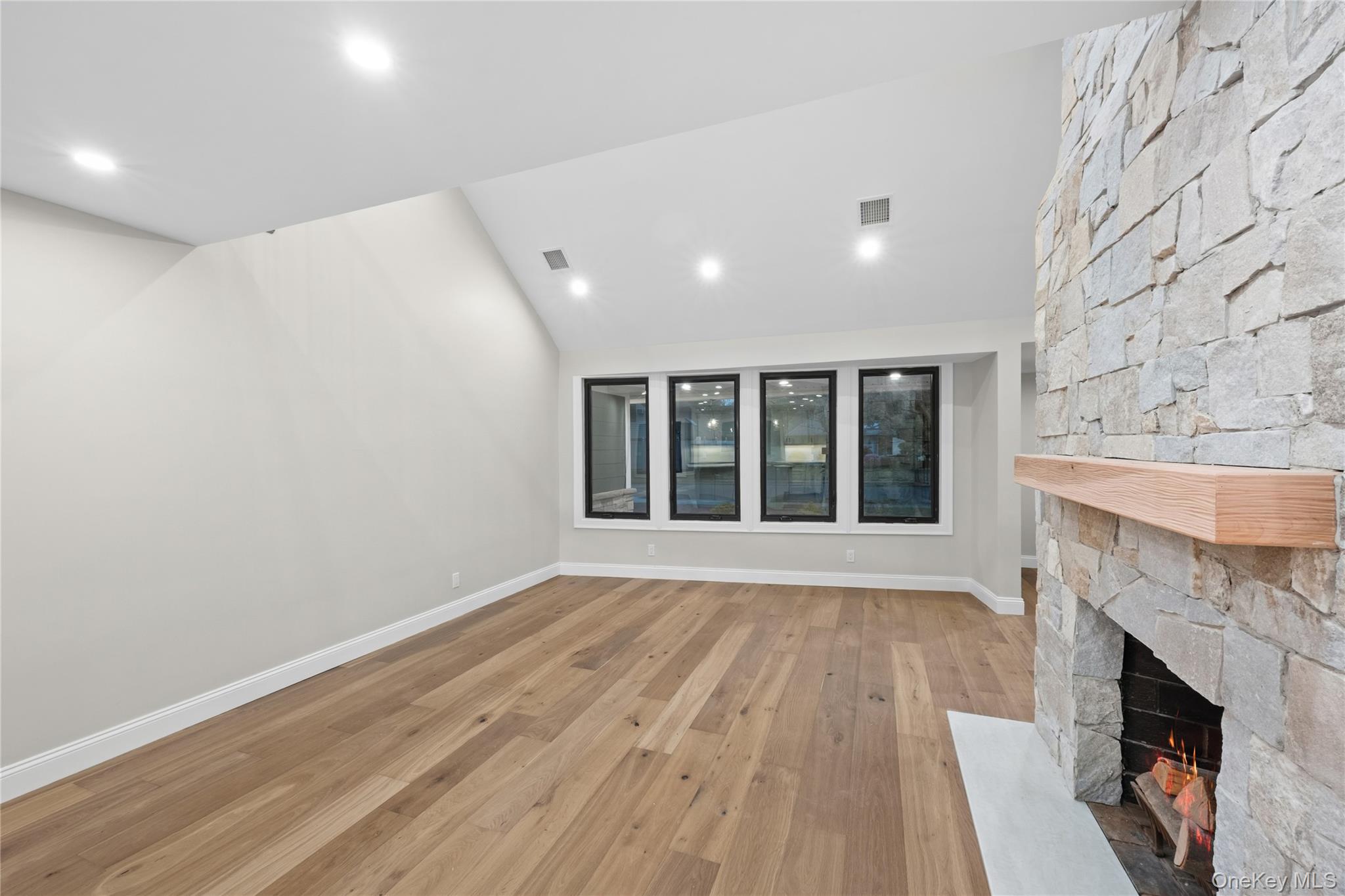11 Ranch Place Merrick, NY 11566 - Photo 13 of 40 a view of an empty room with wooden floor and a fireplace