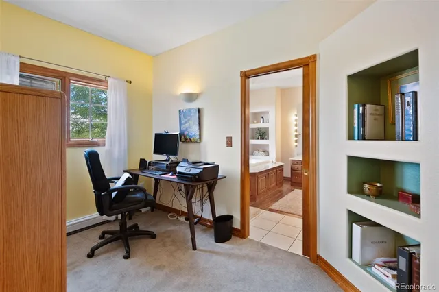 a view of a workspace with furniture and a window