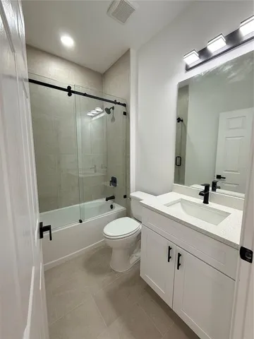 a bathroom with a double vanity sink toilet mirror and shower