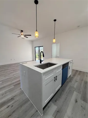 a kitchen with sink cabinets and wooden floor