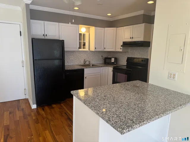 a kitchen with stainless steel appliances granite countertop a refrigerator stove top oven and sink