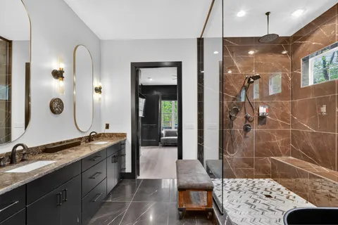 a spacious bathroom with a double vanity sink a mirror and a shower