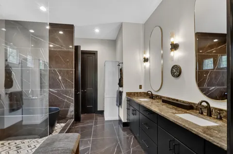 a bathroom with a double vanity sink a toilet and a mirror