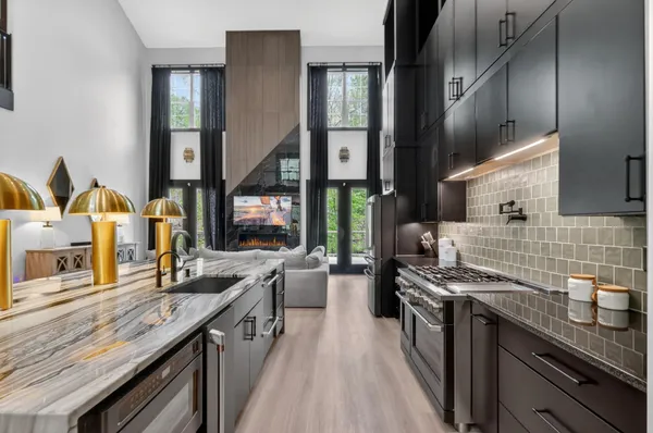 a kitchen with stainless steel appliances granite countertop a sink stove and cabinets