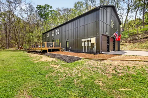 a view of a house with a wooden deck and a swimming pool