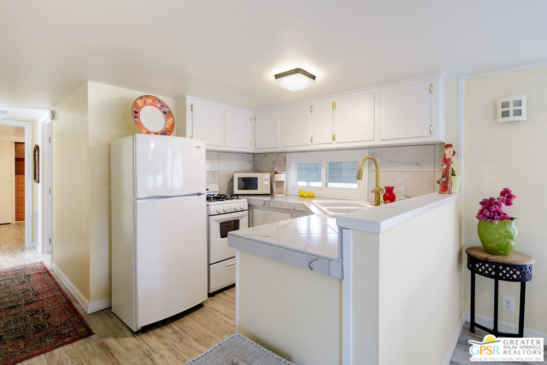 157 Caravan Street Palm Springs, CA 92264 - Photo 15 of 38 a kitchen with refrigerator and cabinets