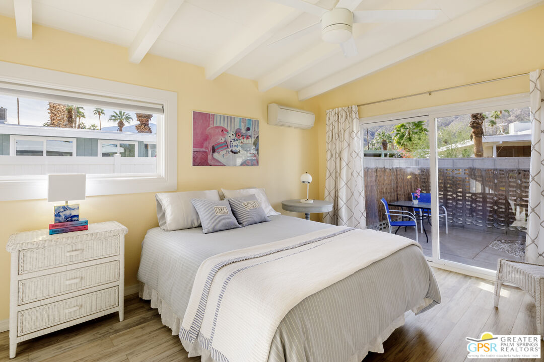 157 Caravan Street Palm Springs, CA 92264 - Photo 16 of 38 a bedroom with a bed and wooden floor