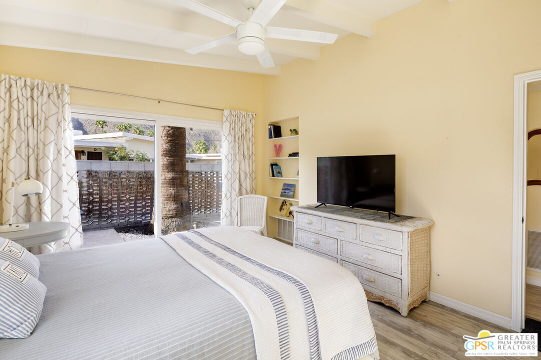 157 Caravan Street Palm Springs, CA 92264 - Photo 17 of 38 a bedroom with a bed and a flat screen tv