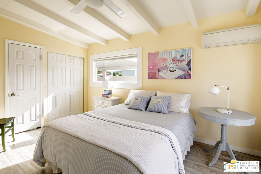 157 Caravan Street Palm Springs, CA 92264 - Photo 18 of 38 a bedroom with a bed and a chandelier