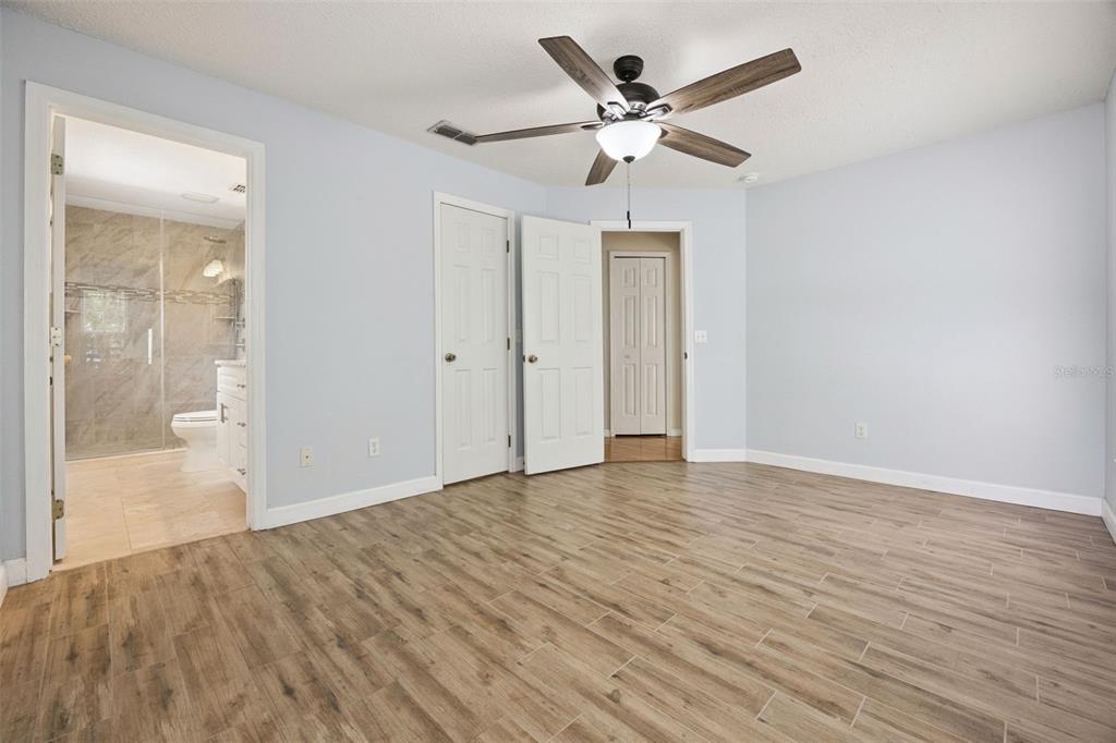 124 Diamond Ridge Boulevard Auburndale, FL 33823 - Photo 10 of 20 an empty room with wooden floor and ceiling fan