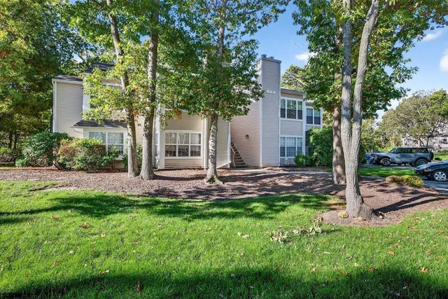 a view of a house with a yard and tree s