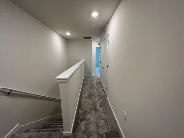 a view of a hallway with a wooden door