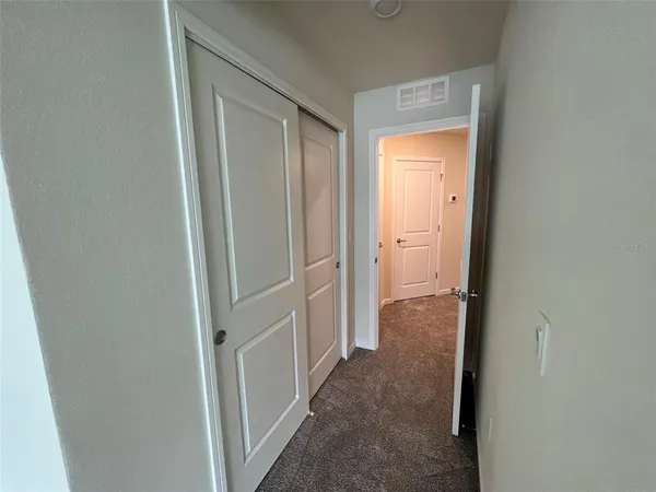 a view of a hallway with a glass door and a bathroom