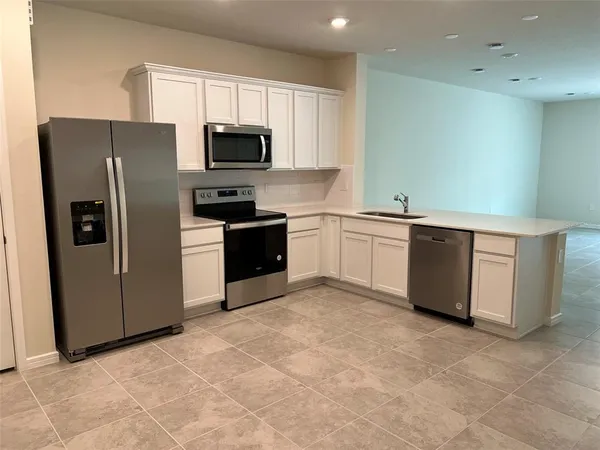 a kitchen with stainless steel appliances granite countertop a refrigerator stove and microwave