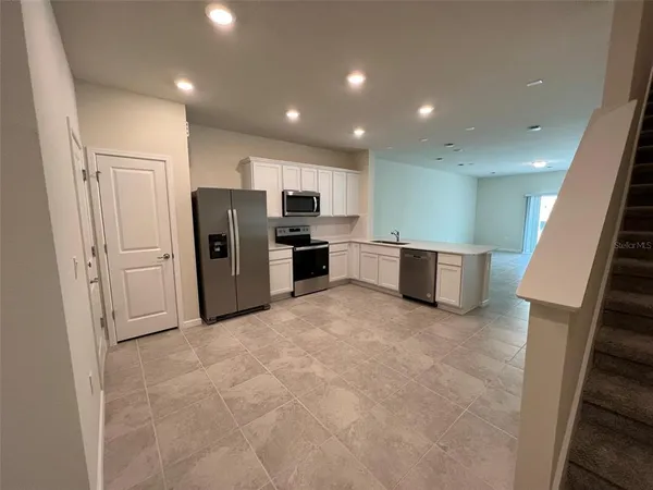 a view of kitchen with refrigerator and microwave