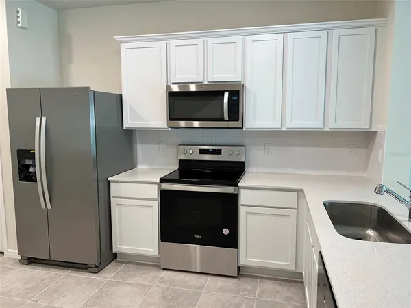 a kitchen with white cabinets and stainless steel appliances