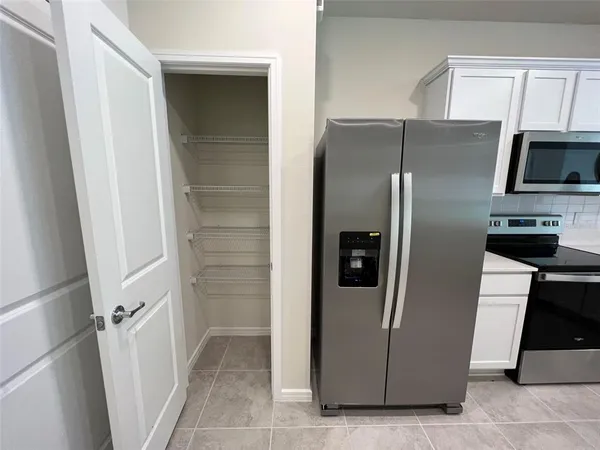 a metallic refrigerator freezer and a stove sitting inside of a kitchen