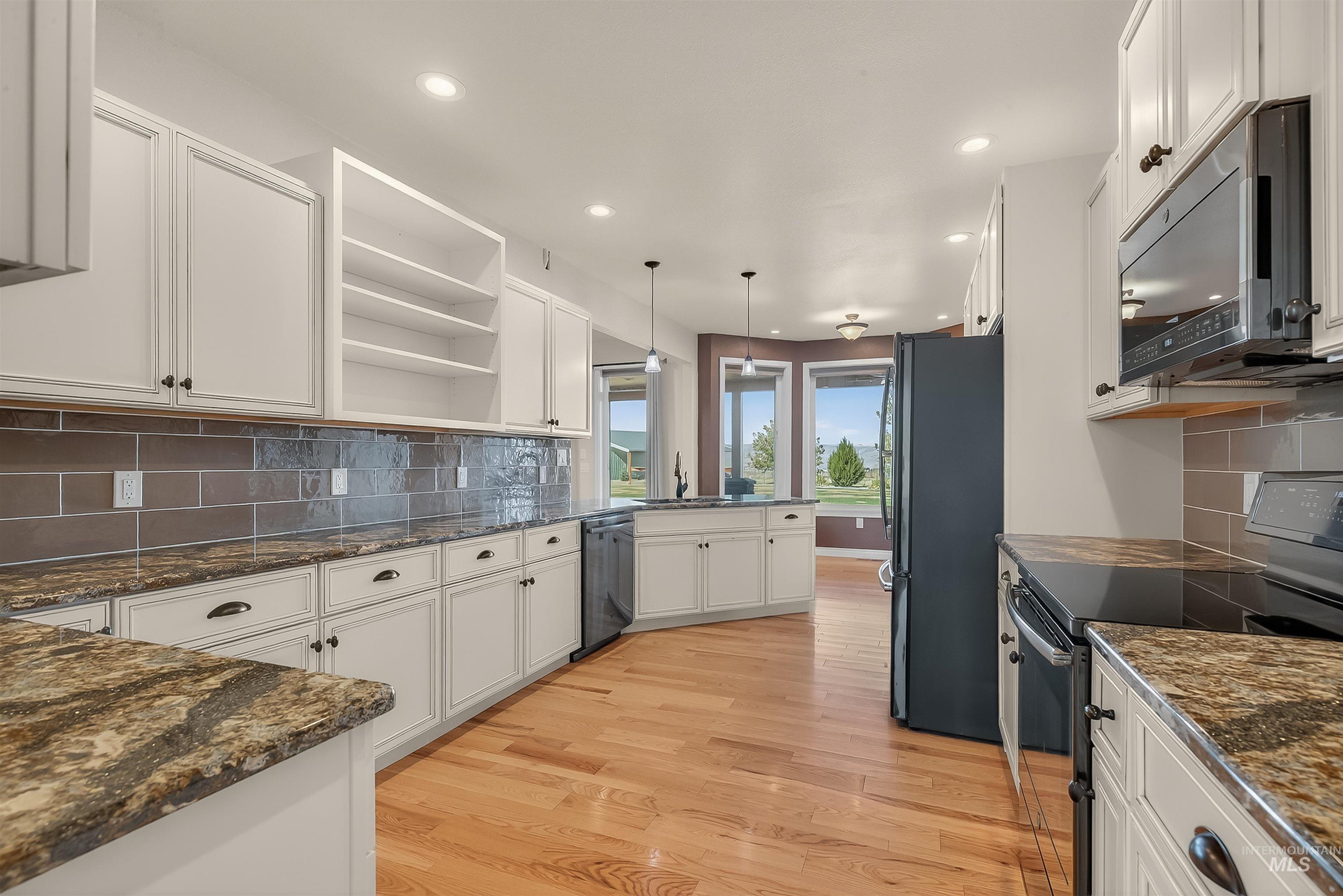 2233 Burrell Avenue Lewiston, ID 83501 - Photo 11 of 48 Kitchen with black appliances, open shelves, backsplash, white cabinetry, and decorative light fixtures