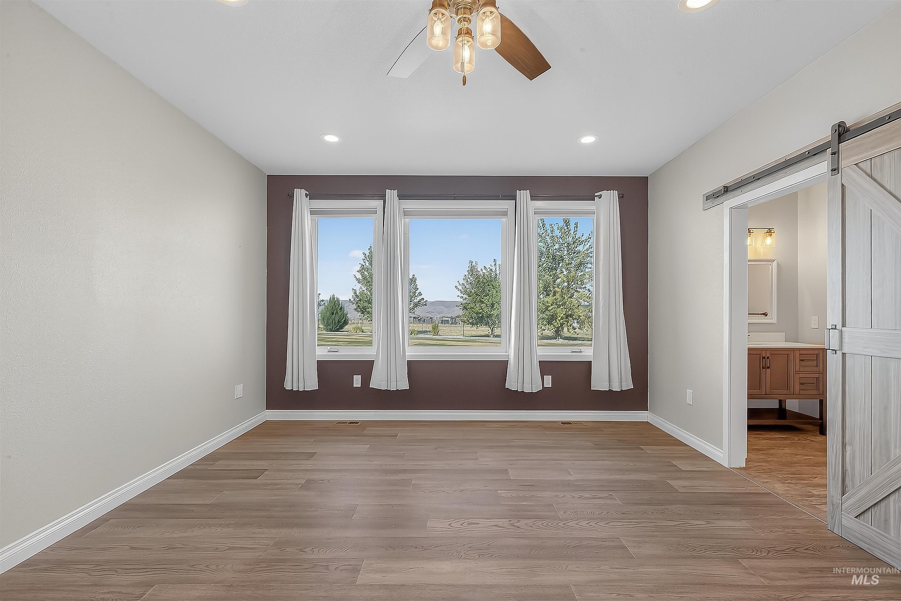 2233 Burrell Avenue Lewiston, ID 83501 - Photo 14 of 48 Empty room featuring a barn door, light wood finished floors, plenty of natural light, and recessed lighting