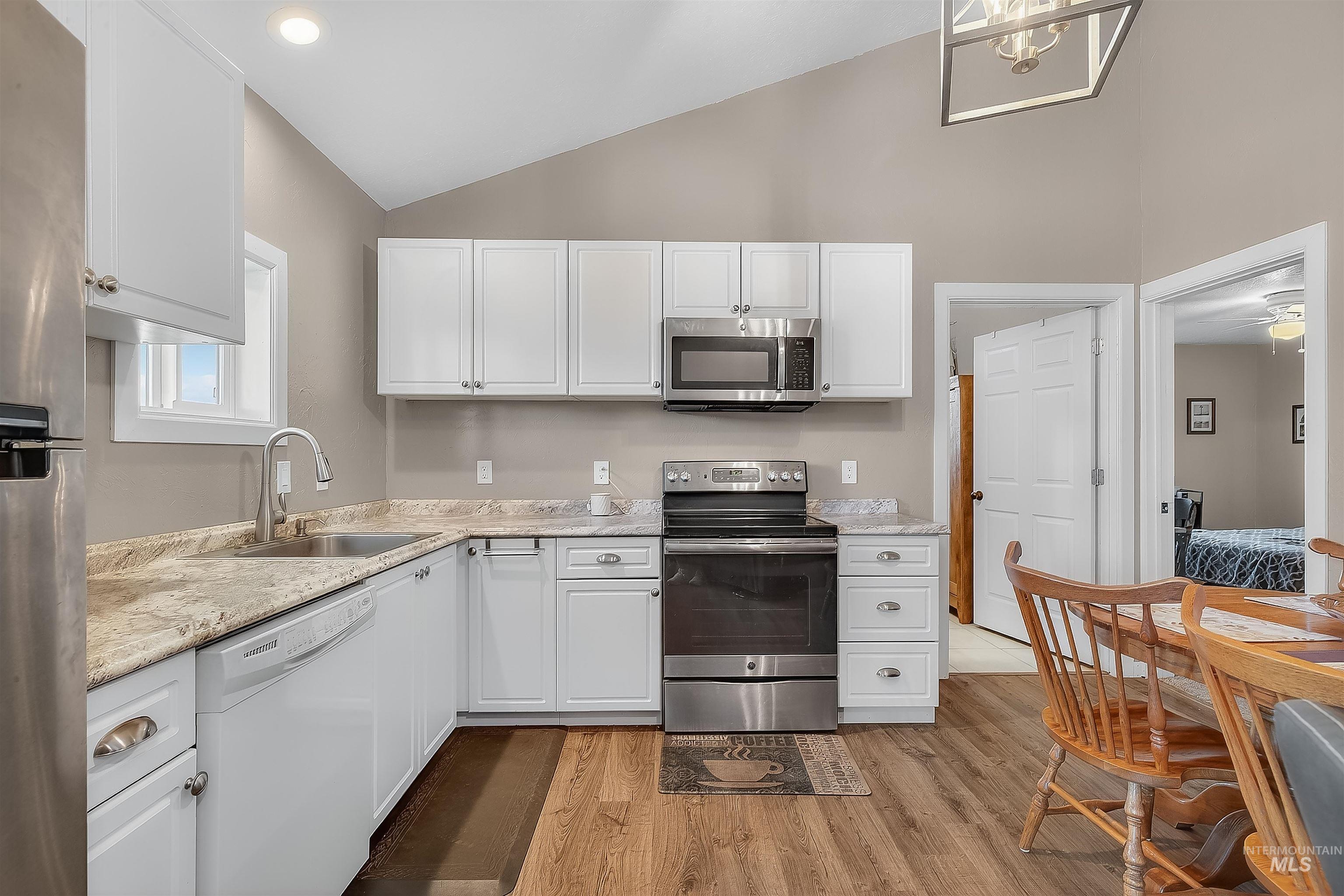 2233 Burrell Avenue Lewiston, ID 83501 - Photo 38 of 48 Kitchen featuring lofted ceiling, appliances with stainless steel finishes, white cabinets, light wood-style floors, and recessed lighting