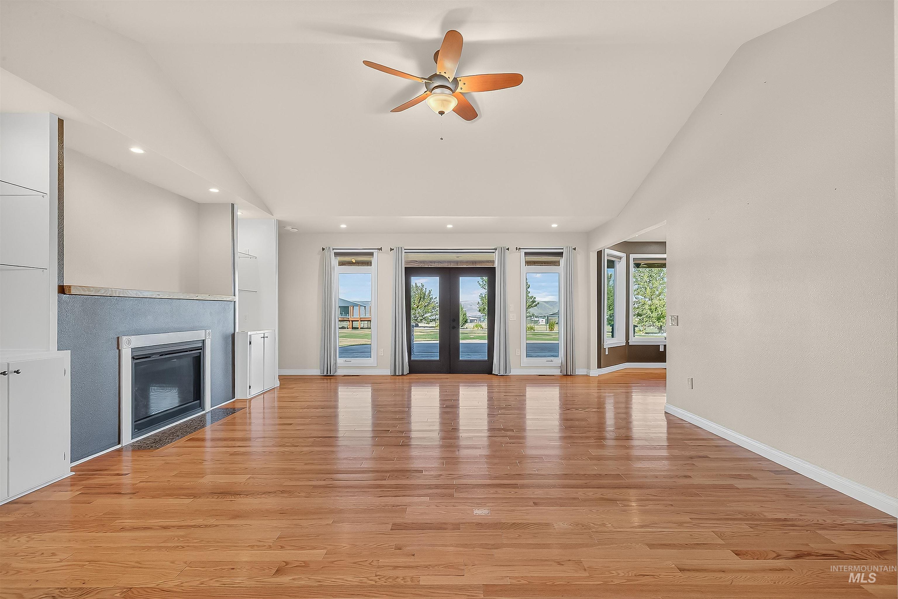 2233 Burrell Avenue Lewiston, ID 83501 - Photo 7 of 48 Unfurnished living room featuring healthy amount of natural light, light wood-style flooring, a glass covered fireplace, french doors, and recessed lighting