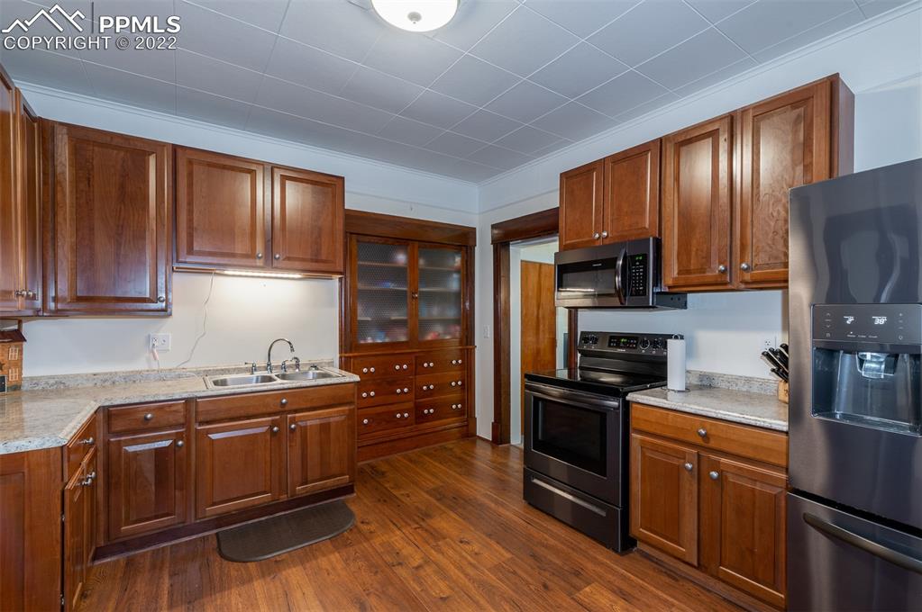 210 South 2nd Street Victor, CO 80860 - Photo 19 of 30 a kitchen with stainless steel appliances a sink cabinets and wooden floor