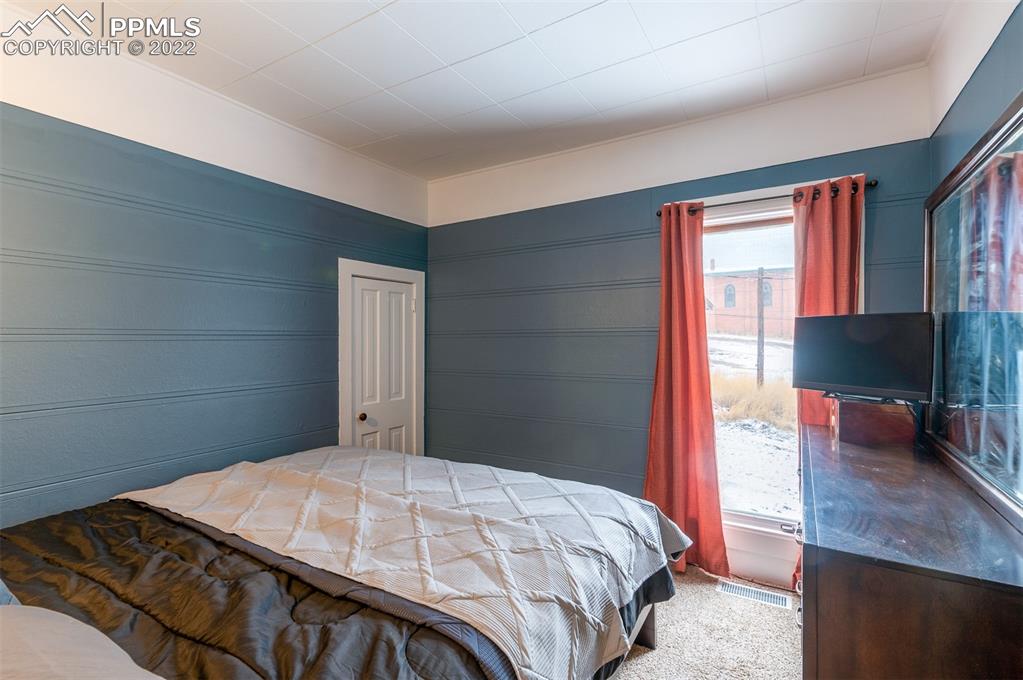 210 South 2nd Street Victor, CO 80860 - Photo 26 of 30 a bedroom with a bed and a flat screen tv
