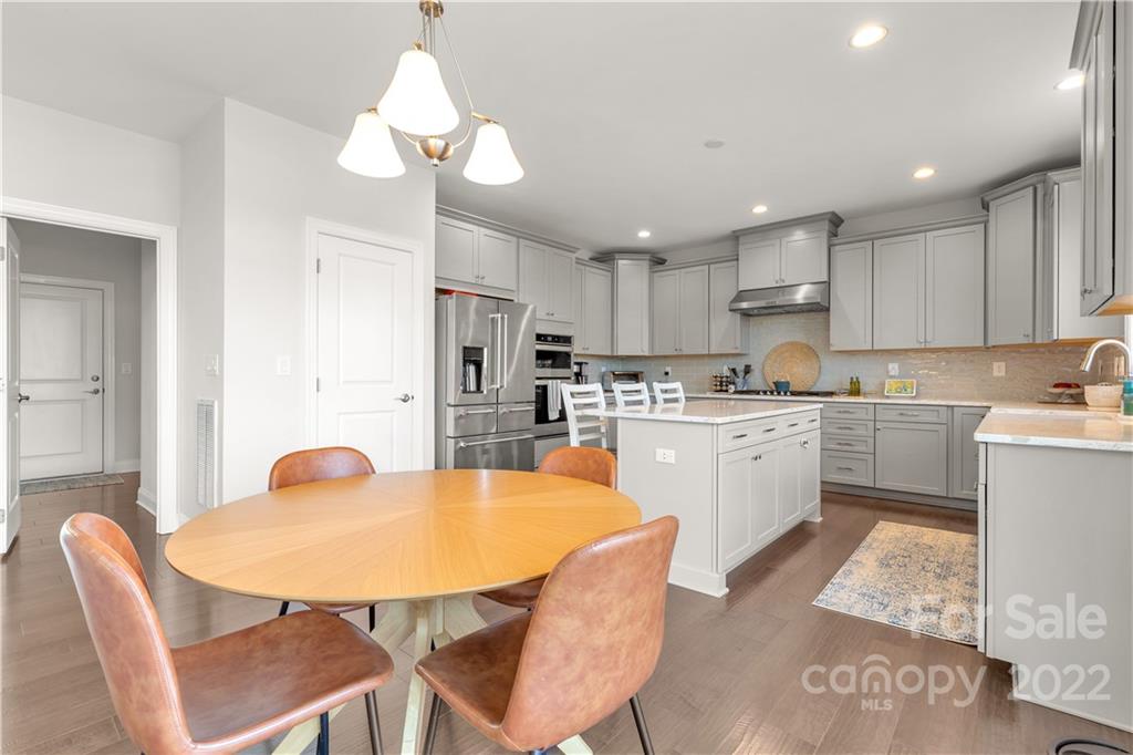 6028 Candlestick Lane Lancaster, SC 29720 - Photo 11 of 34 a kitchen with stainless steel appliances kitchen island granite countertop a sink dishwasher a stove a refrigerator with a dining table and chairs