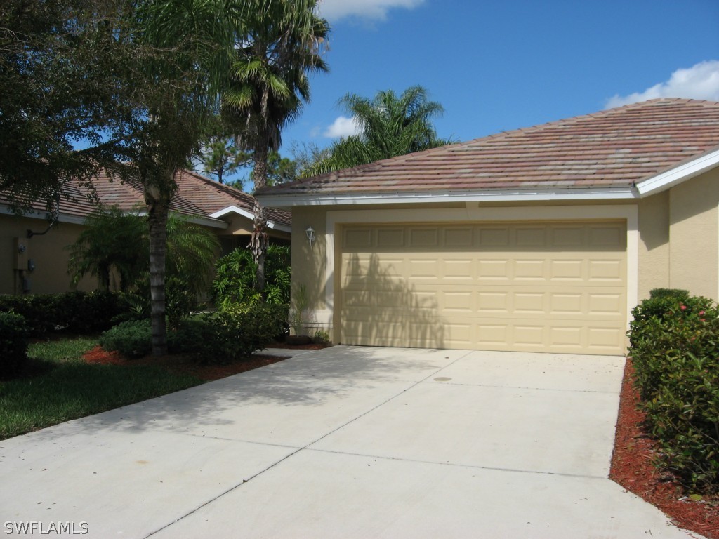 4676 Fairloop Run Lehigh Acres, FL 33973 - Photo 1 of 21 a front view of a house with garden