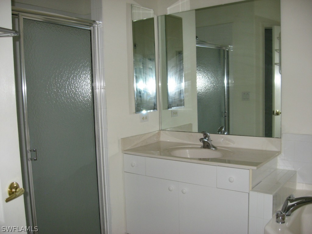 4676 Fairloop Run Lehigh Acres, FL 33973 - Photo 16 of 21 a bathroom with a sink and a mirror