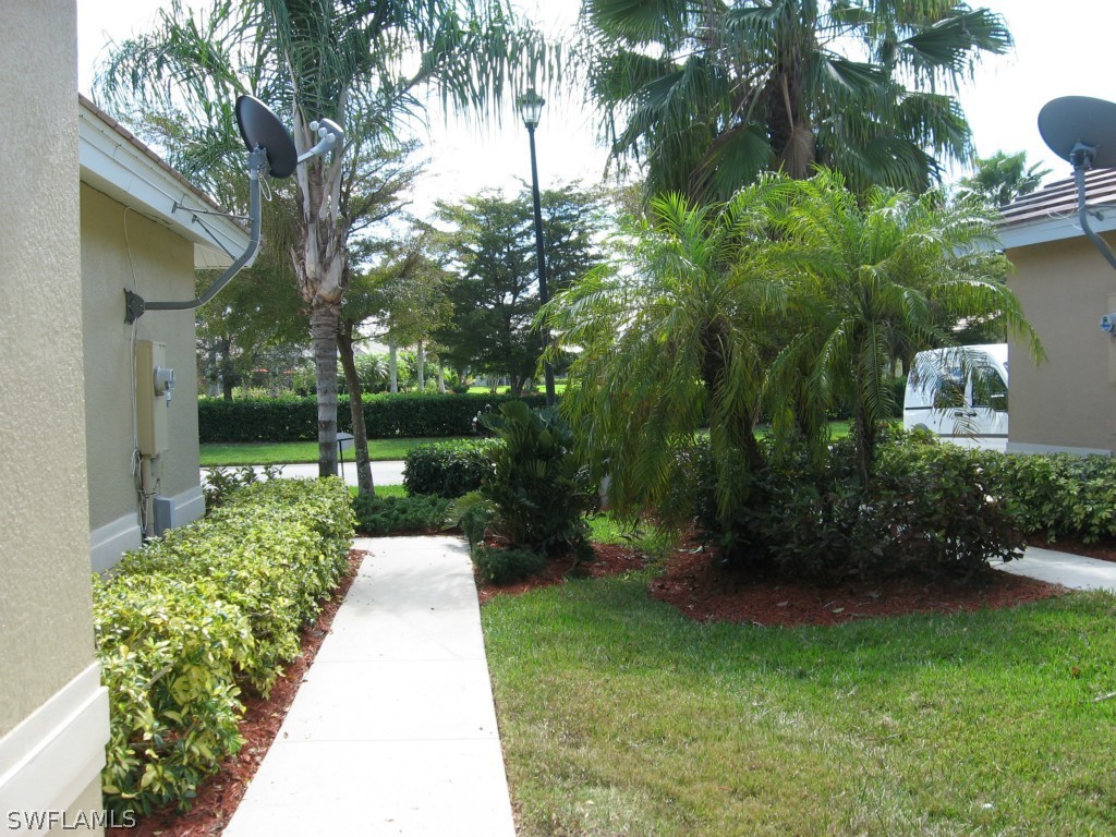 4676 Fairloop Run Lehigh Acres, FL 33973 - Photo 2 of 21 a view of a garden with a fountain