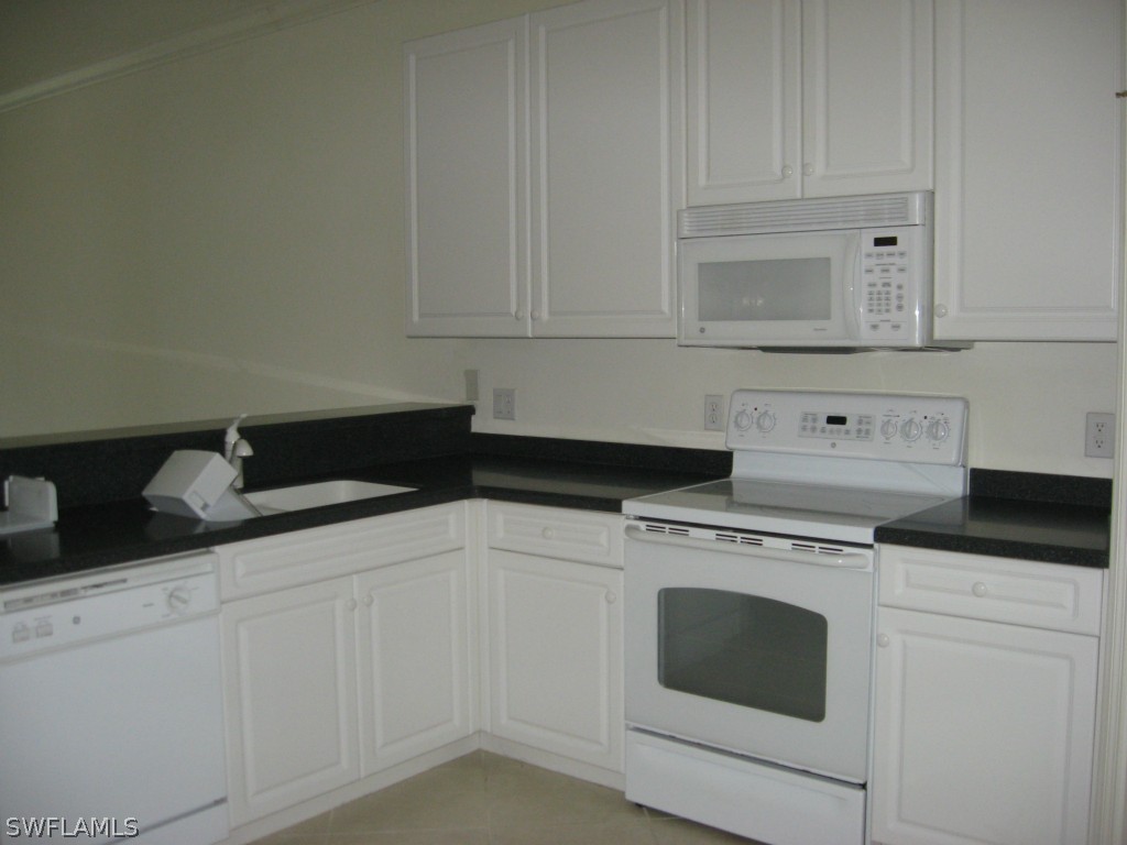 4676 Fairloop Run Lehigh Acres, FL 33973 - Photo 5 of 21 a kitchen with granite countertop white cabinets and white appliances